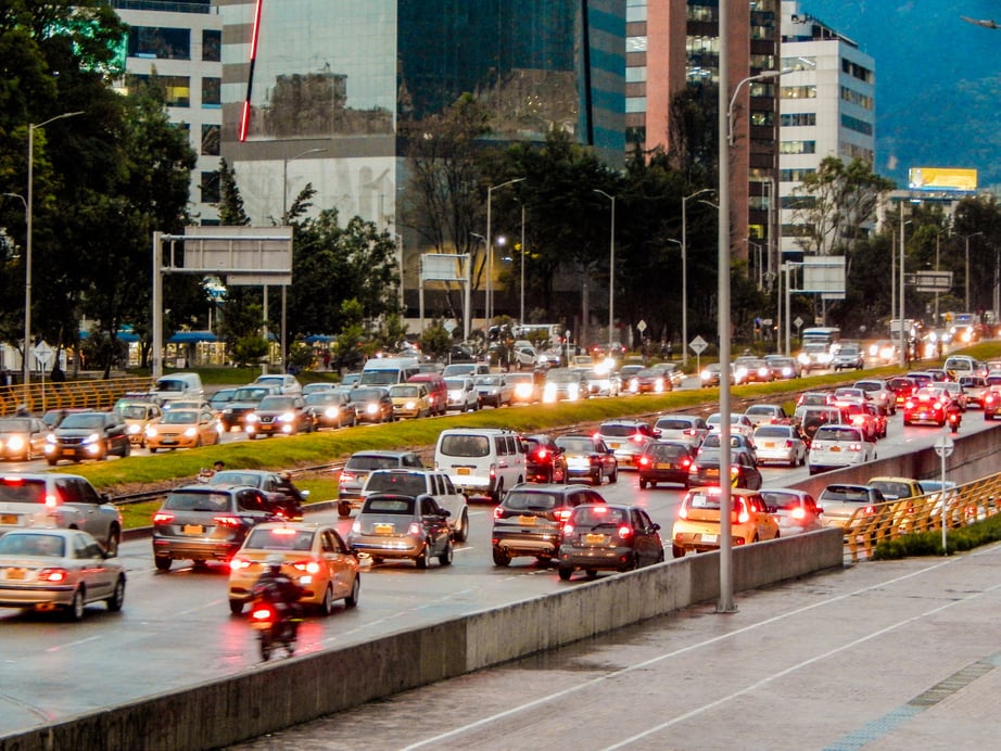 Cars in traffic in both ways and trees and buildings in Bogota Colombia